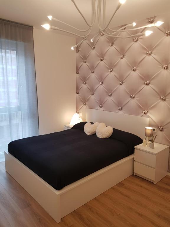 um quarto com uma cama grande e uma cabeceira acolchoada em BSUITES TRIESTE em Pádua