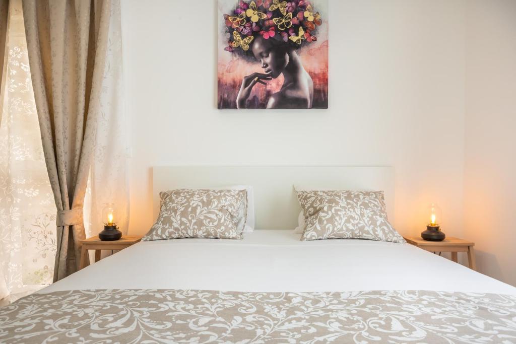 a bedroom with a bed with two pillows and a painting at Luxury apartments Nikolina Sea&City view in Makarska
