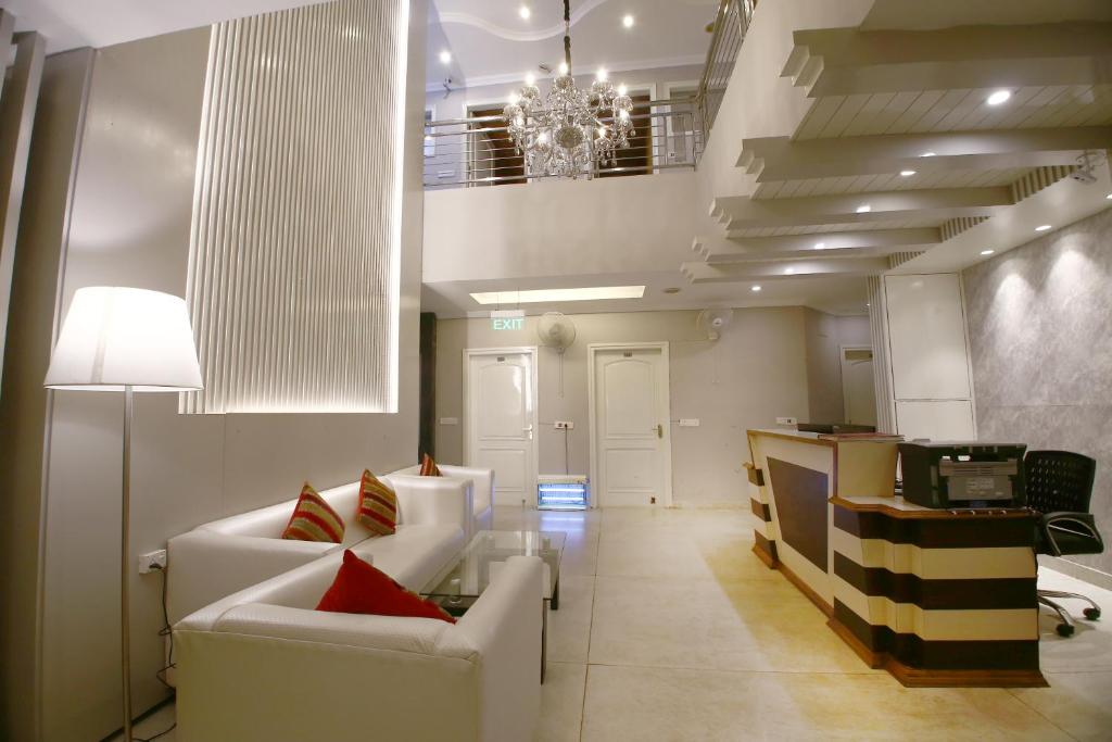 uma sala de estar com mobiliário branco e um lustre em Hotel Diamond Plaza em Chandīgarh
