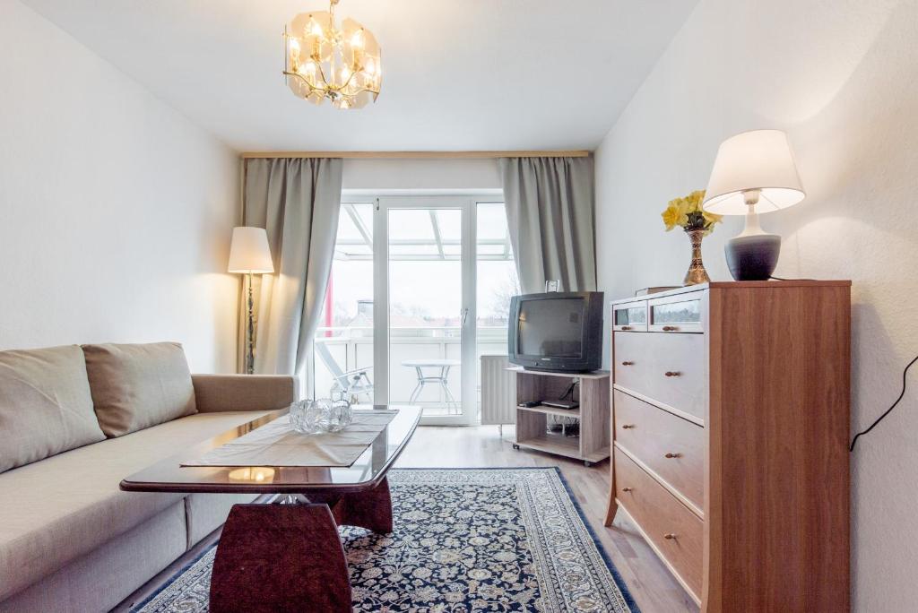 ein Wohnzimmer mit Couch und Fernseher in der Unterkunft Private Apartment in Hannover