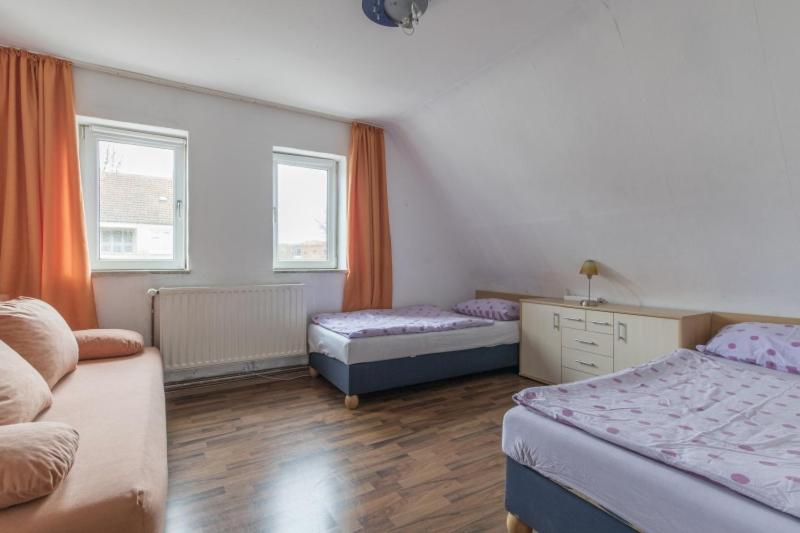 una camera con due letti e un divano di Private Apartment ad Hannover