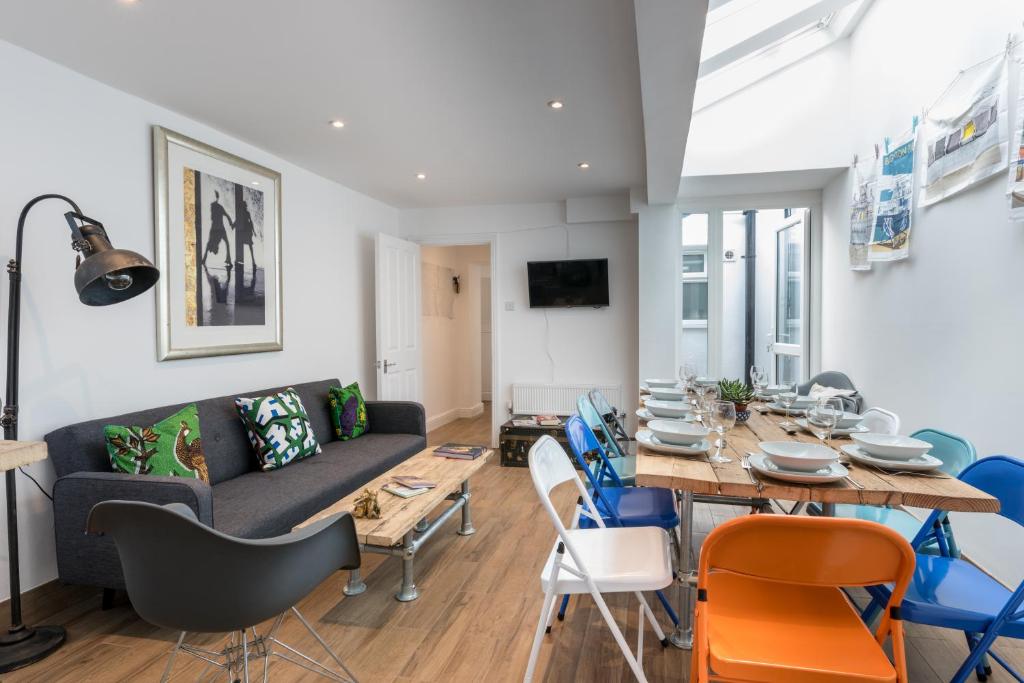 een woonkamer met een bank en een tafel en stoelen bij Brighton City Centre Luxury House in Brighton & Hove