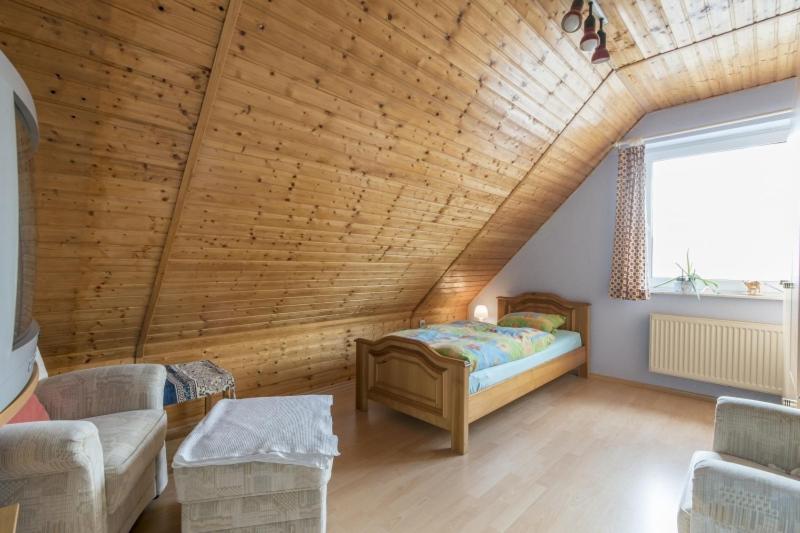 1 dormitorio con cama y techo de madera en Private Rooms, en Gestorf