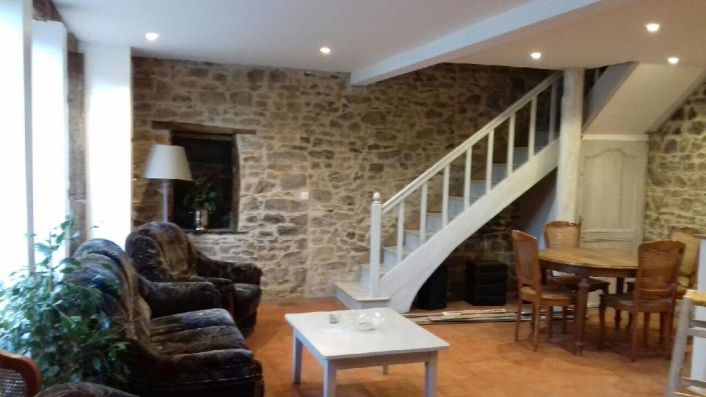 uma sala de estar cheia de mobiliário e uma parede de pedra em Les Tilleuls em La Porcherie