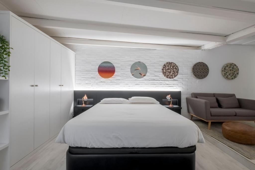 a bedroom with a bed and a couch at Malasaña Boutique in Madrid