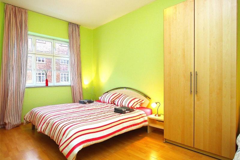 ハノーファーにあるPrivate Roomの緑のベッドルーム(ベッド1台、窓付)