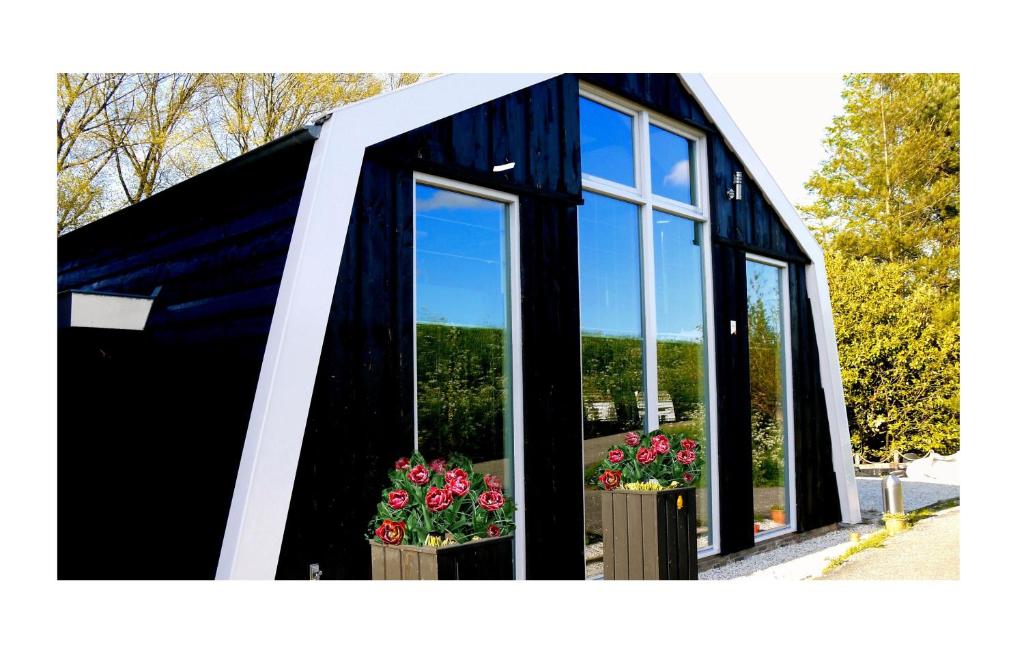 a black and white building with windows and flowers at Markermeerlogies in Bovenkarspel