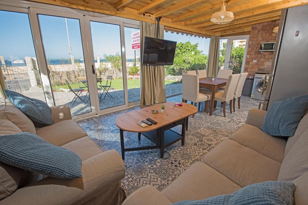 ein Wohnzimmer mit Sofas, einem Tisch und einem TV in der Unterkunft One Bedroom Chalet managed by Lilly Apartments in Hurghada