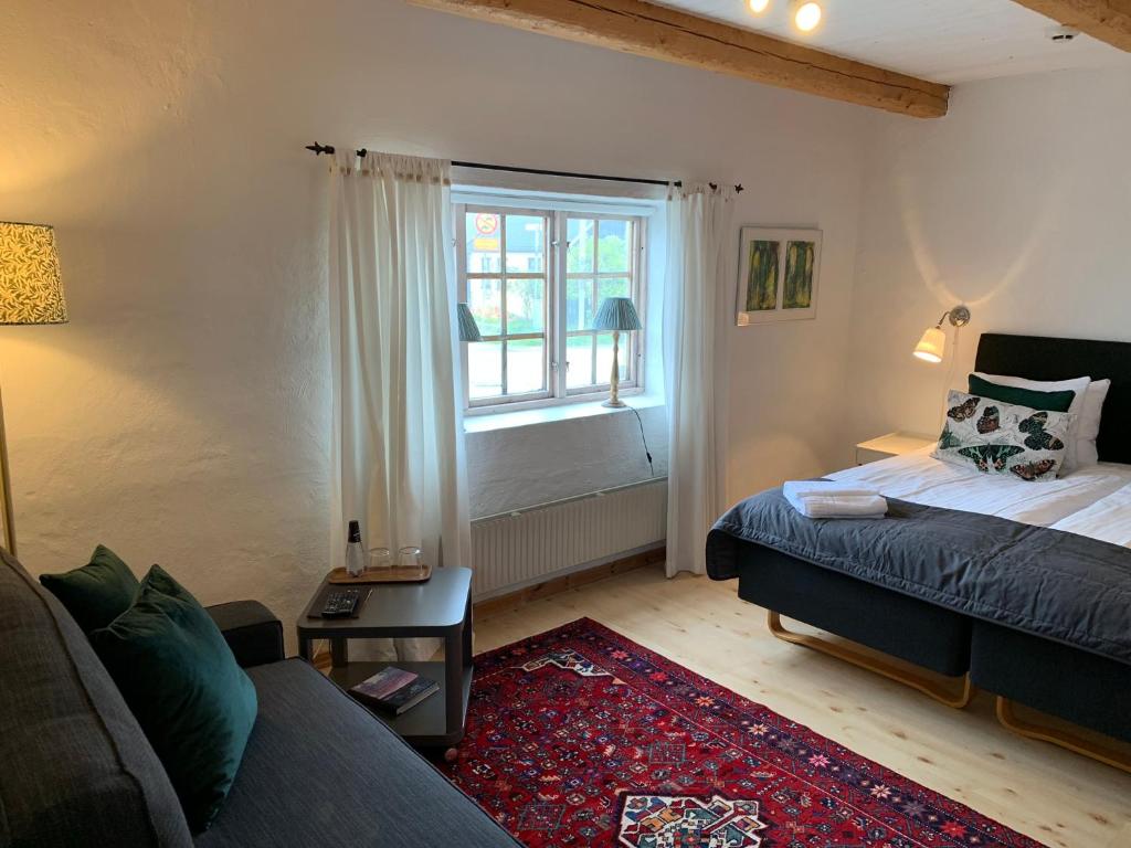 a living room with a bed and a window at Bobergs på Hamngården in Brantevik
