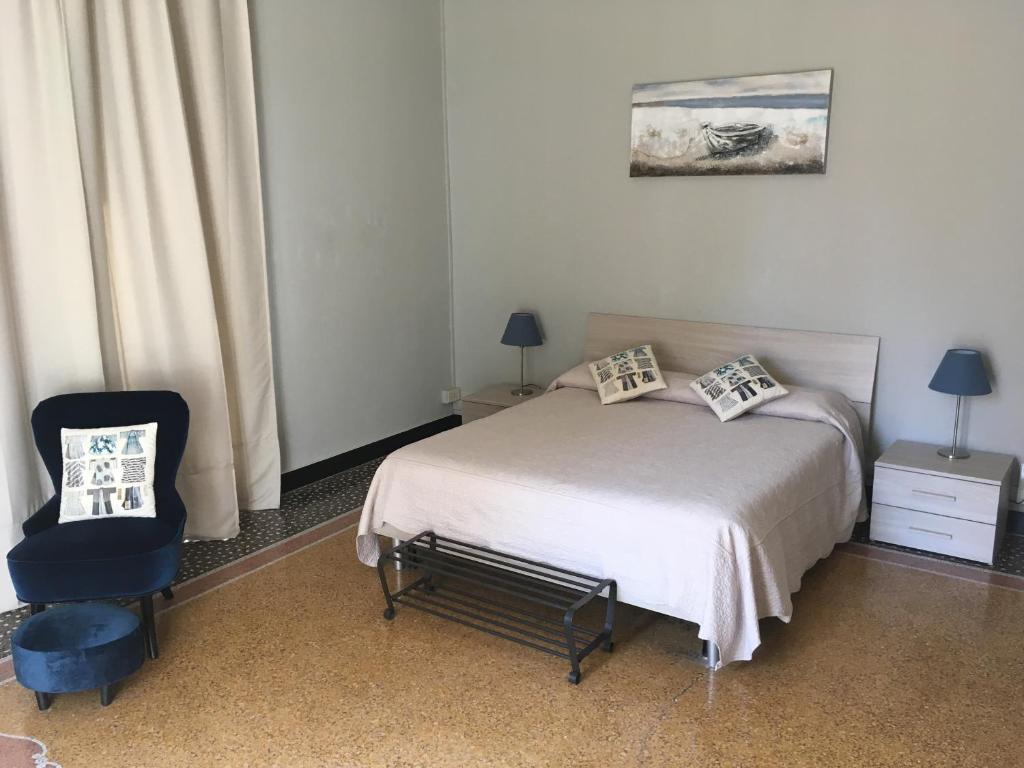 1 dormitorio con 1 cama y 1 silla en Check-Inn Rooms Genova Centro, en Génova