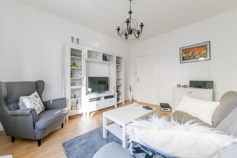 ein Wohnzimmer mit einem Sofa und einem Stuhl in der Unterkunft Private Apartment in Hannover