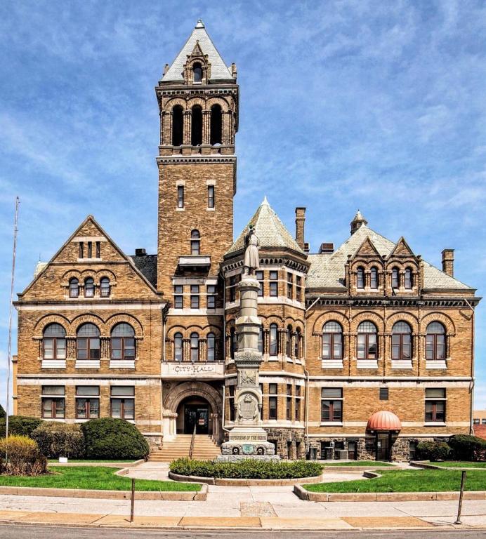 un gran edificio de ladrillo con una torre de reloj en City Hall Grand Hotel, en Williamsport