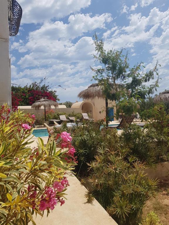 a resort with a swimming pool and some flowers at Menzel Churasco Djerba in Aghīr