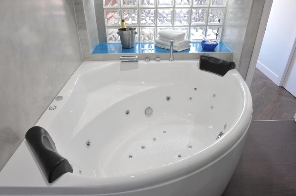 a white bath tub in a bathroom with a window at Gaudint Barcelona Suites in Barcelona