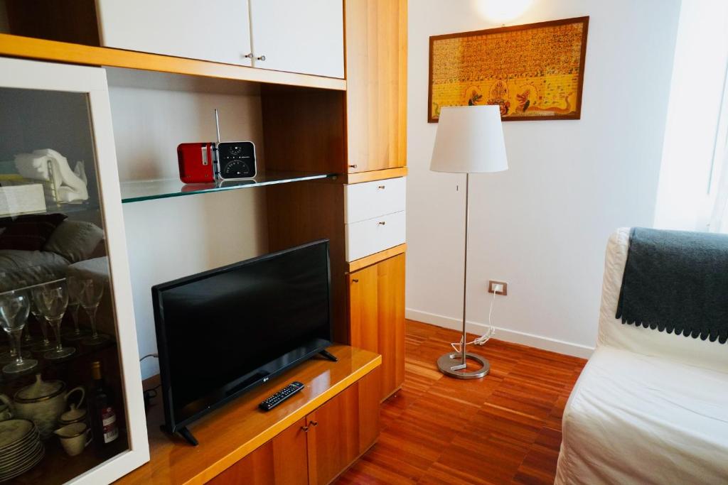 salon z telewizorem, łóżkiem i lampą w obiekcie A Casa di Enza w Bolonii