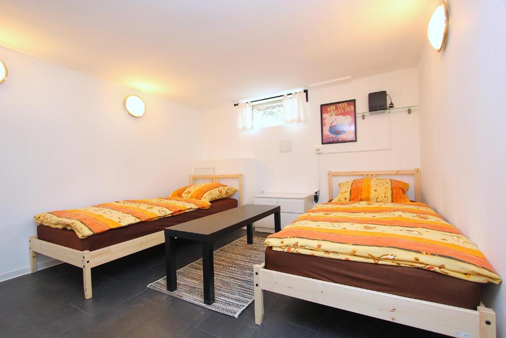 ハノーファーにあるPrivat-Souterrain-Apartmentのベッドルーム1室(ベッド2台、テーブル付)