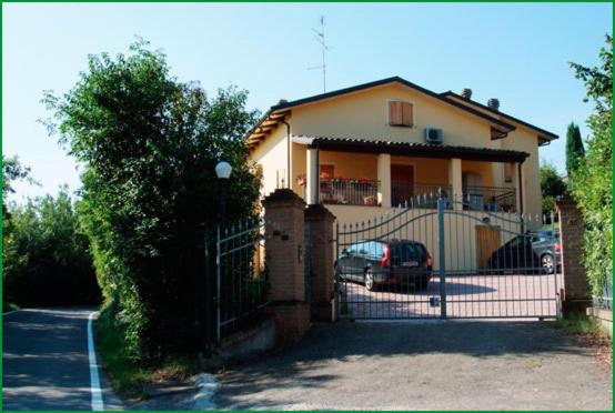a house with a gate and a car parked in front at B&B La Pilastrina in Maranello
