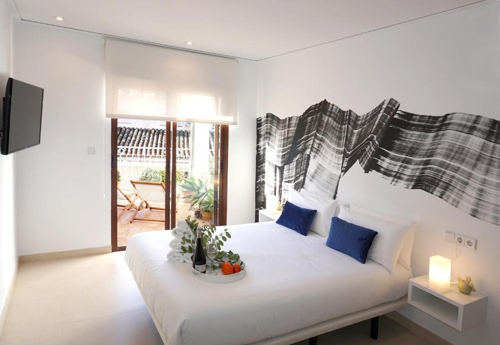 Un dormitorio con una gran cama blanca con almohadas azules. en Mardenit Hotel Boutique, en Orba