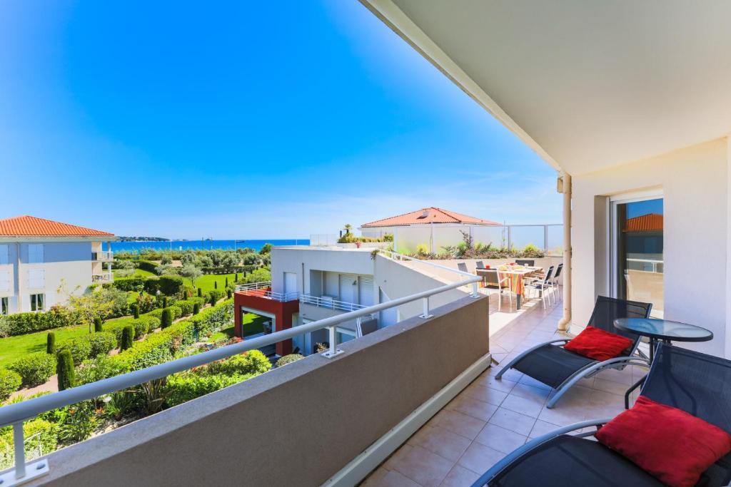 Un balcón con sillas y vistas al océano. en JUAN FLORE AP2035 - Juan-Les-Pins, by Riviera Holiday Homes en Juan-les-Pins