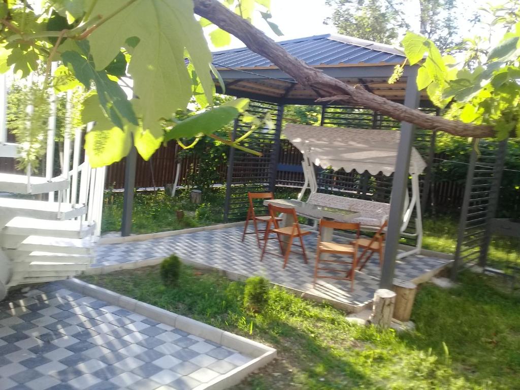 een patio met een tafel en stoelen en een prieel bij Guest house Medea in Koetaisi