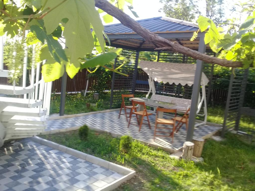 a patio with a table and chairs and a gazebo at Guest house Medea in Kutaisi