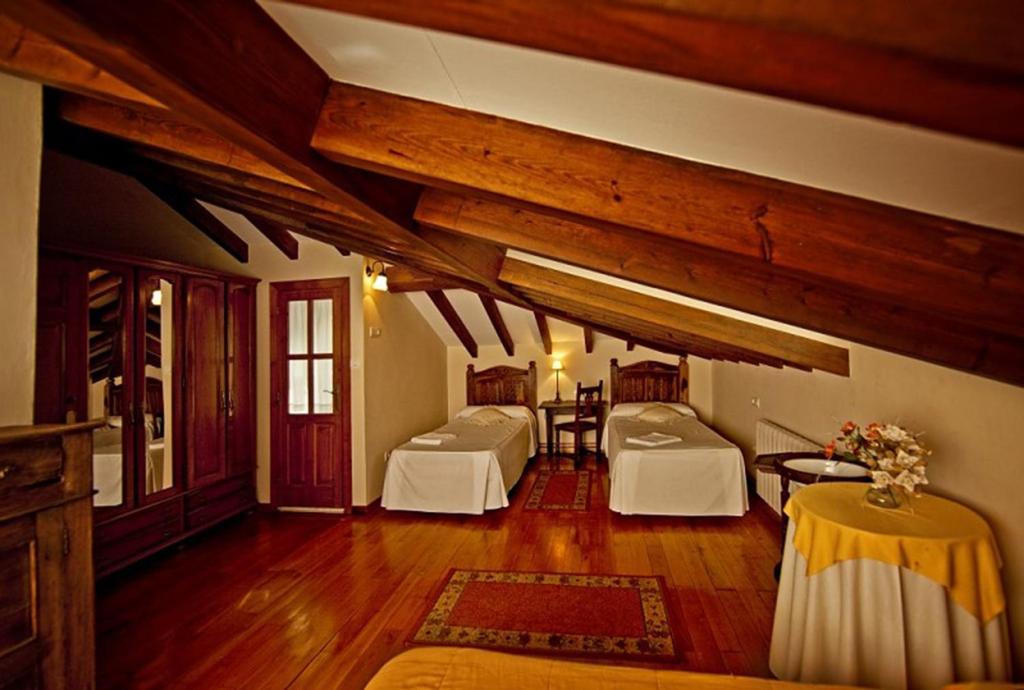 een kamer met twee bedden en een tafel erin bij El Camino Real II * in Poo de Cabrales