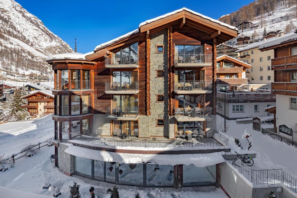 ein Haus in den Bergen mit Schnee in der Unterkunft Hotel Phoenix in Zermatt