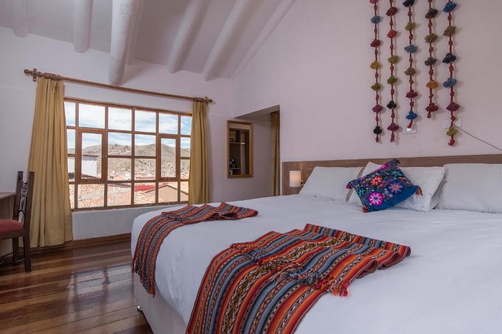 a bedroom with two beds and a window at Inkarri Cusco in Cusco