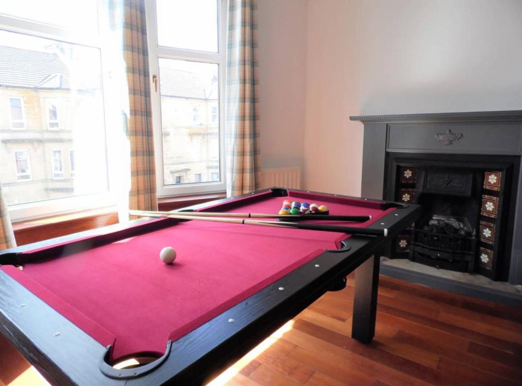 a pool table in a living room with a red cover at 4 Bed Apartment, Paisley - Near GLA Airport in Paisley
