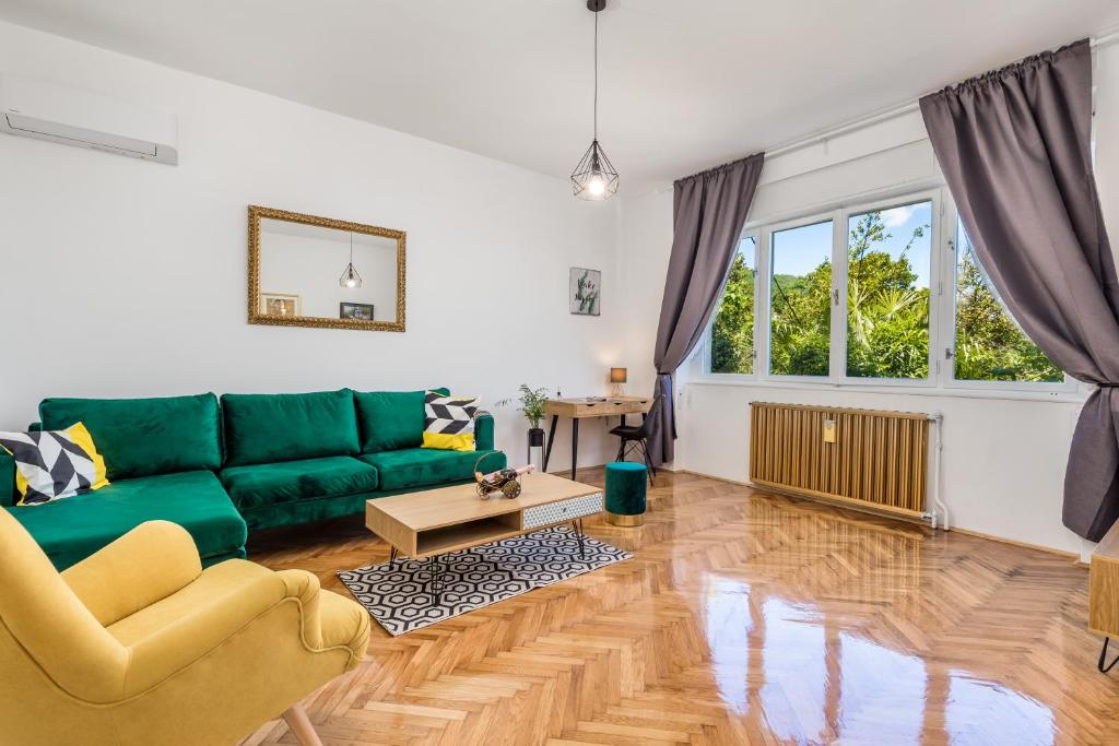 a living room with a green couch and a table at Family House Sara in Ičići