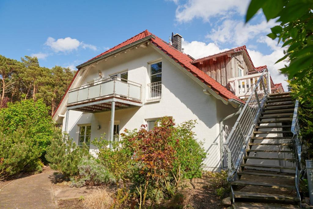 ein weißes Haus mit Treppen, die zu ihm führen in der Unterkunft Sommerhaus Thiessow in Thiessow