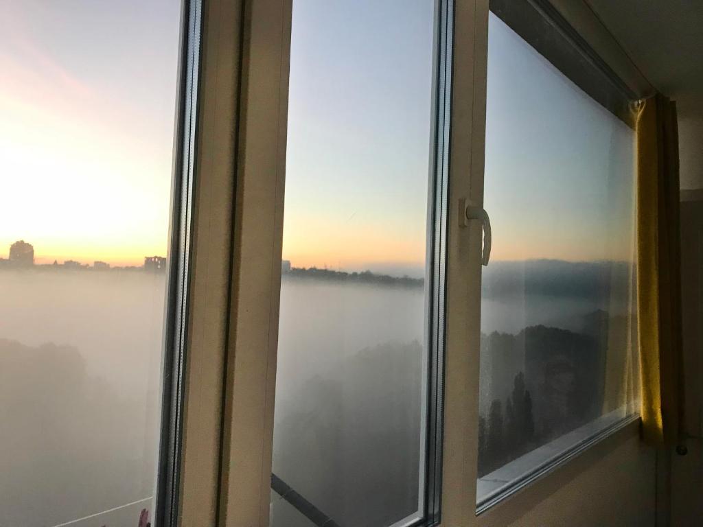 una ventana abierta con vistas a la niebla en Fantastic View on Chisinau Center - Super Fast WiFi - Two Botanical Gardens - 2BR en Chişinău