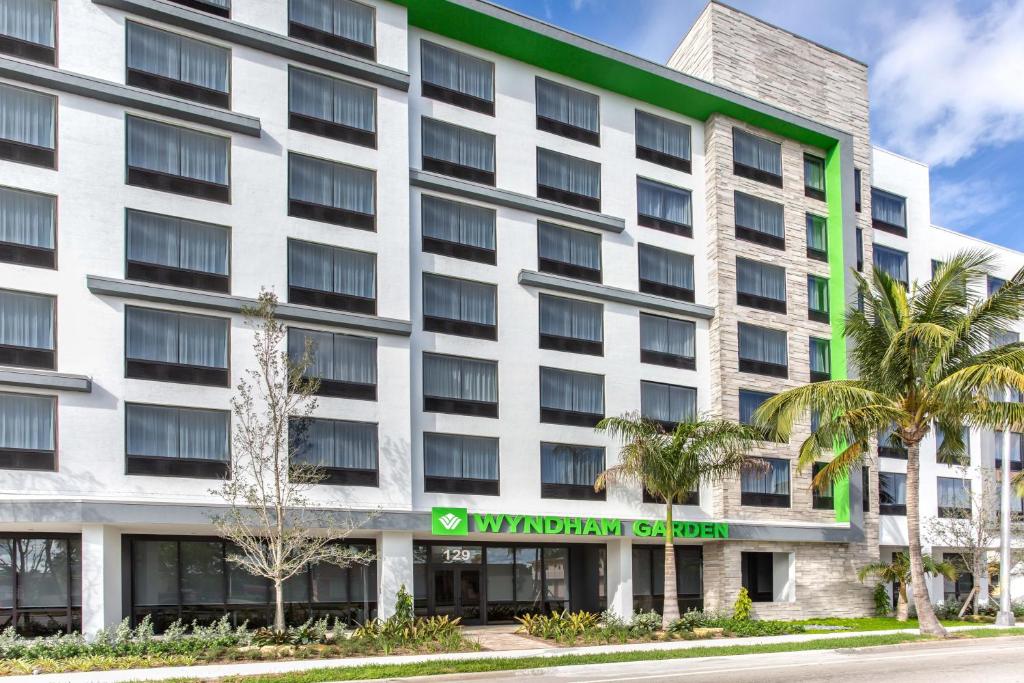 an exterior view of a building with palm trees at Wyndham Garden Ft Lauderdale Airport & Cruise Port in Dania Beach