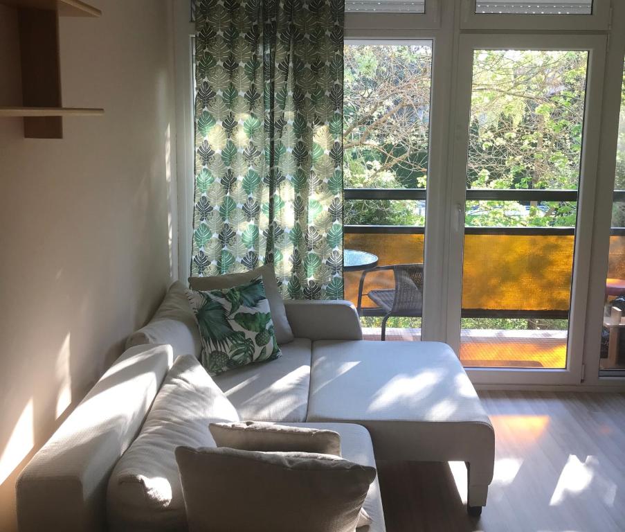 a living room with a white couch and a large window at Adrian's Home in Balatonfüred
