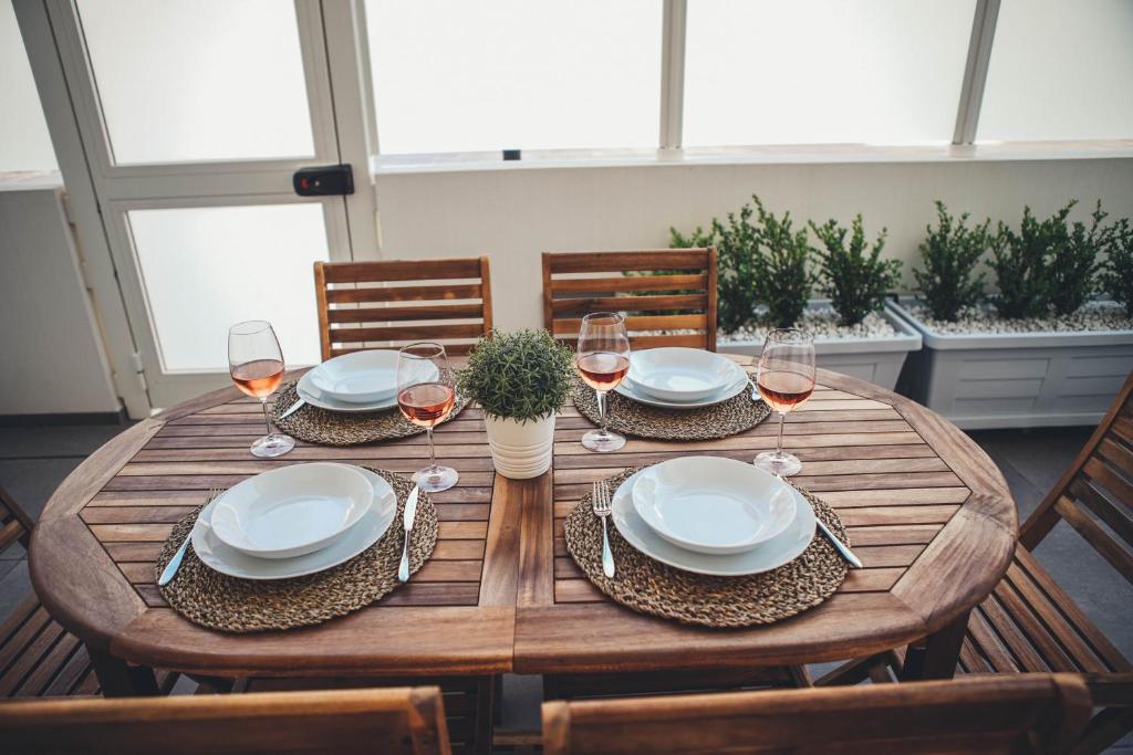 a wooden table with plates and glasses of wine at Terradamare in Monopoli