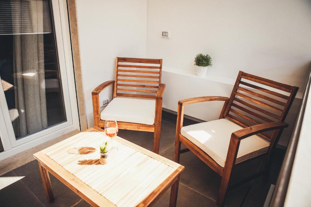 a room with two chairs and a table with a glass of wine at Terradamare in Monopoli