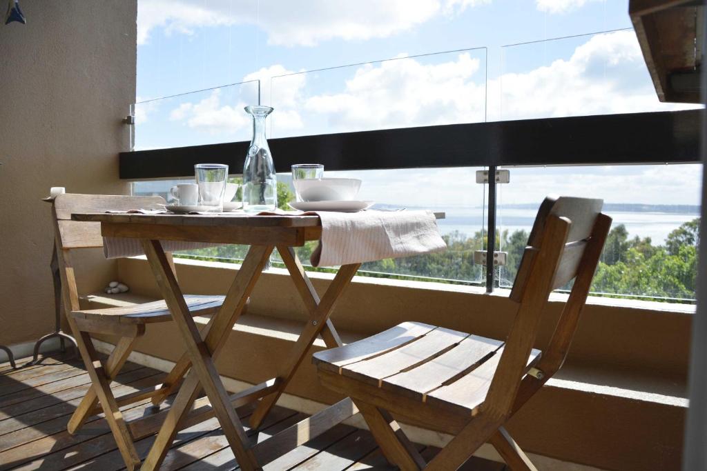a table and chairs sitting in front of a window at Alto da Barra 186E - Parking & Sea View in Oeiras