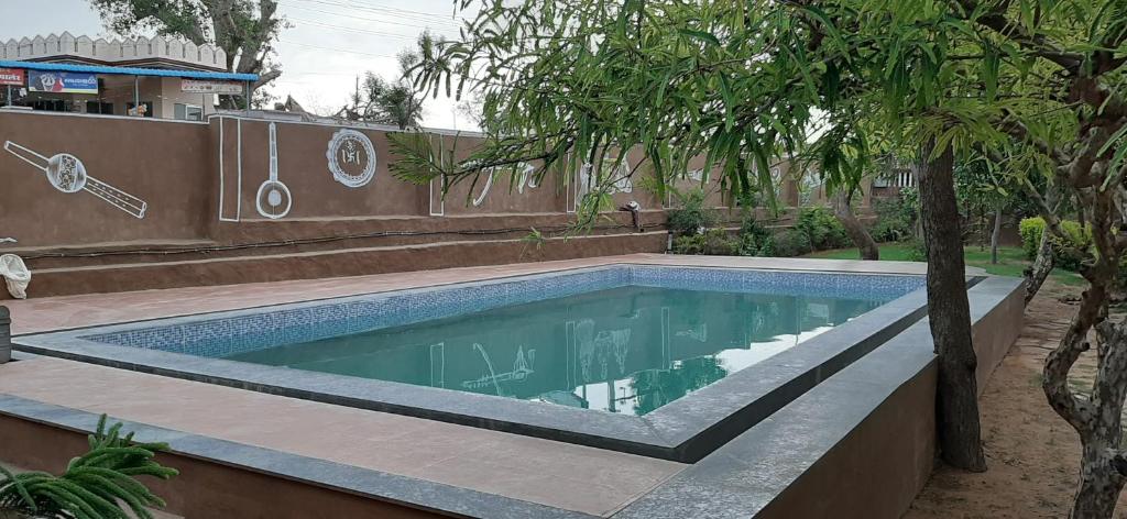 einen Pool in einem Garten mit Bäumen in der Unterkunft Pushkar Vela Resort in Pushkar