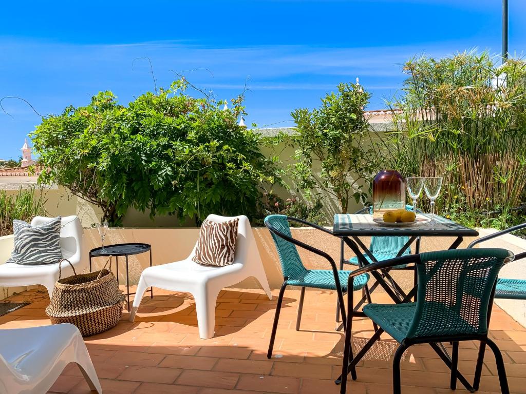 een patio met een tafel en stoelen bij Casa Silwa - Chic 2BR Townhouse, Ocean Views, 5min to Beach & Pool in Ferragudo