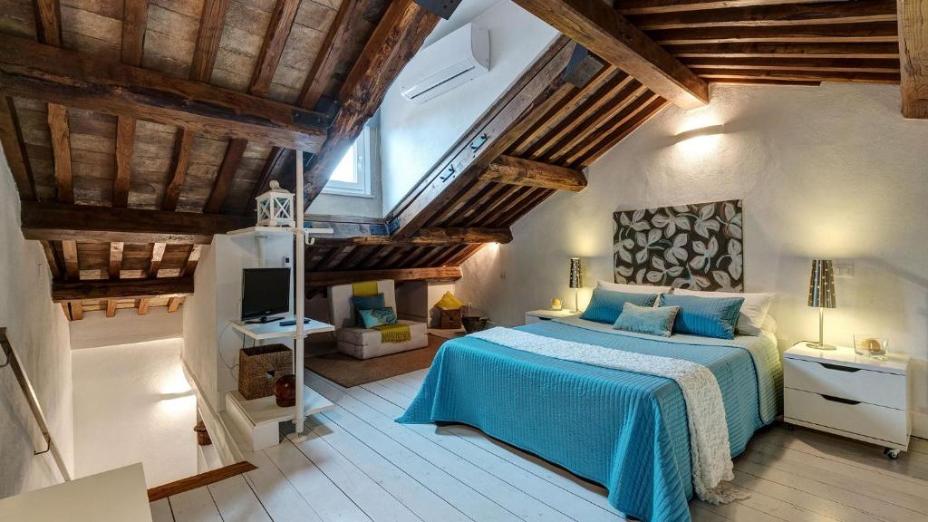 sypialnia z niebieskim łóżkiem i drewnianym sufitem w obiekcie La Colombaia Nel Castello w mieście Bracciano