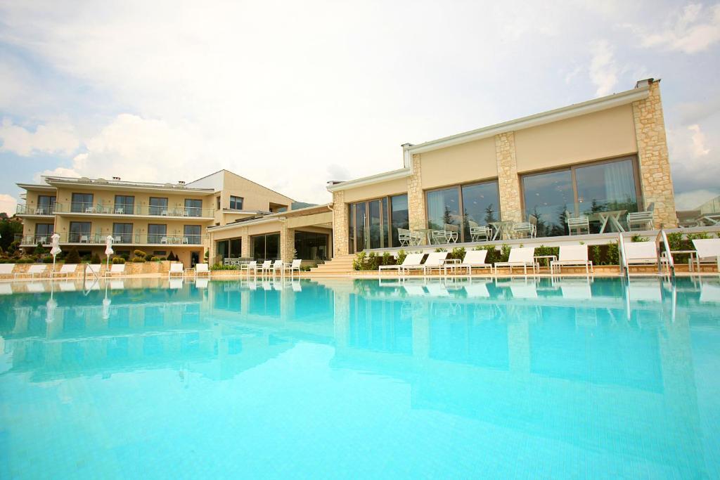 uma grande piscina em frente a um hotel em Calma Hotel & Spa em Castória