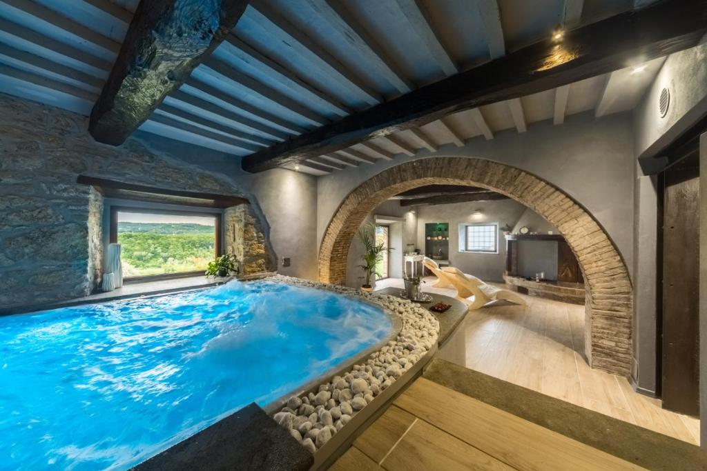 una gran piscina en una casa con un arco en I Segreti del Borgo, en Penna in Teverina