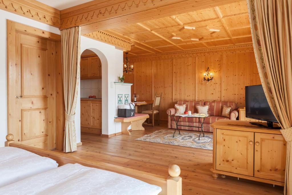 a bedroom with a bed and a tv in a room at Hotel Lärchenhof Natur in Seefeld in Tirol