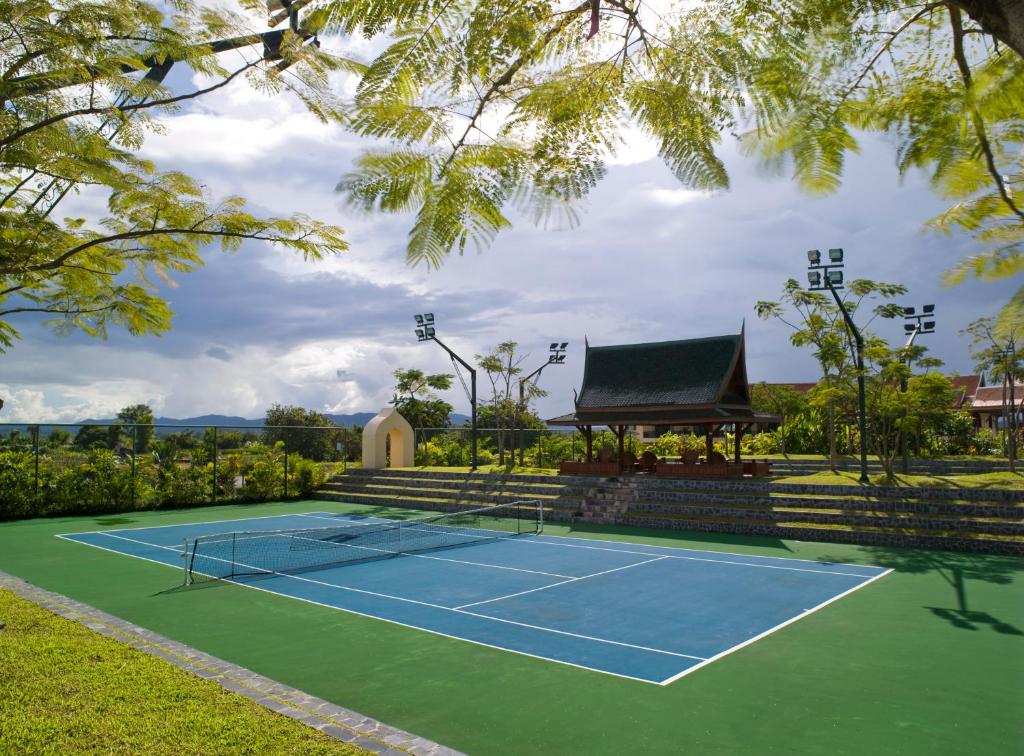 a tennis court in front of a house at Rico Resort in Chiang Kham