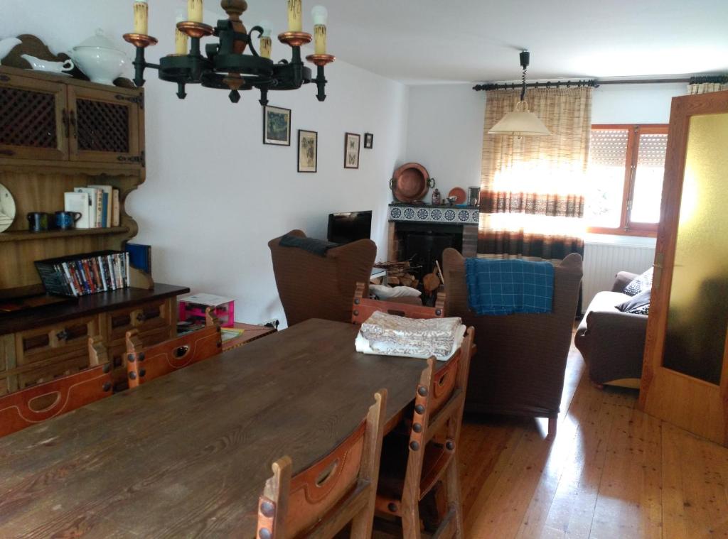 salon z drewnianym stołem i krzesłami w obiekcie Los Valles 4 w mieście Biescas