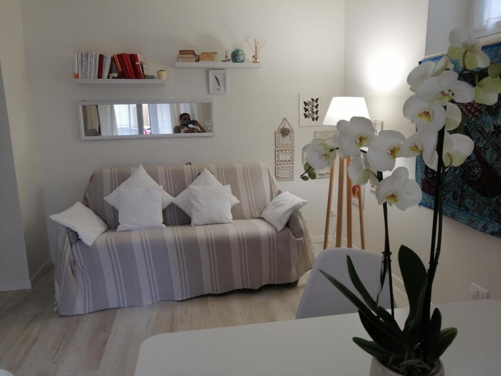 ein Wohnzimmer mit einem Sofa und weißen Kissen in der Unterkunft La Casa Di Pepe in Sanremo