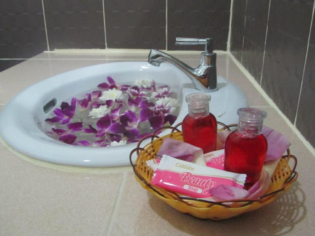 a bathroom sink with a bowl of flowers and two jars at Grand View in Patong Beach