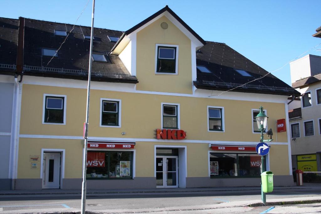 un bâtiment jaune au coin d'une rue dans l'établissement Cityhouse Apartments Schladming, à Schladming