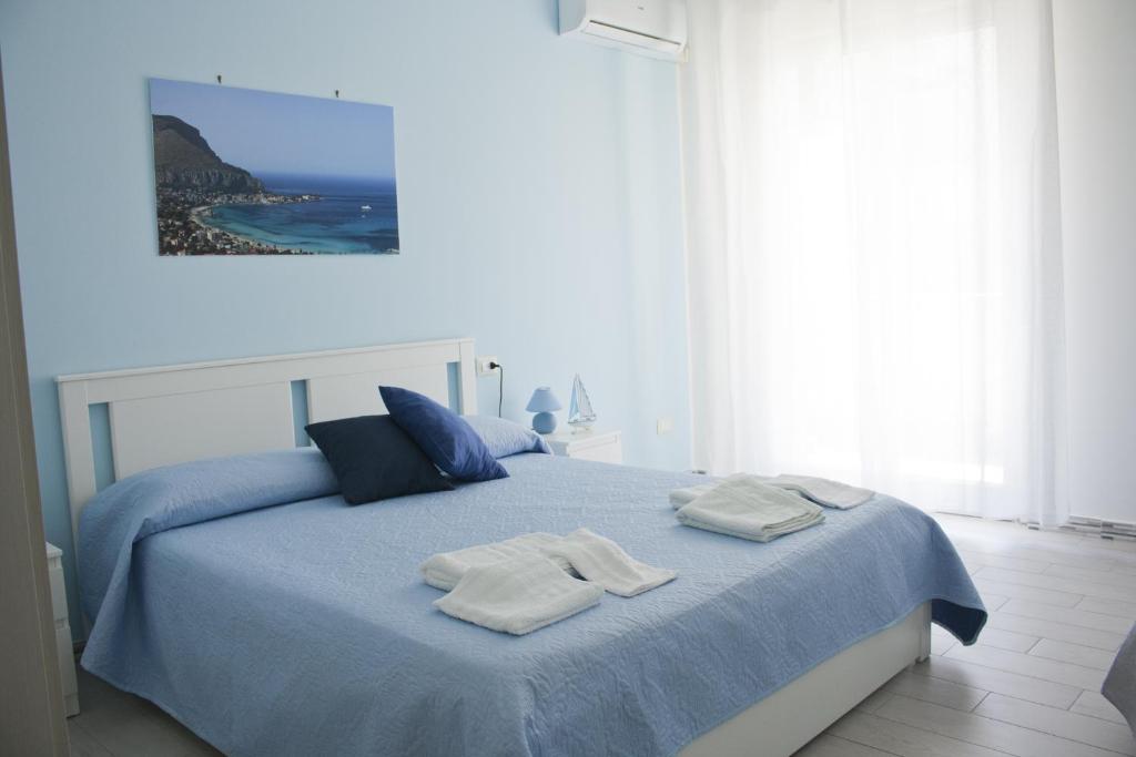 ein Schlafzimmer mit einem blauen Bett und Handtüchern darauf in der Unterkunft B&B d'Orleans in Palermo