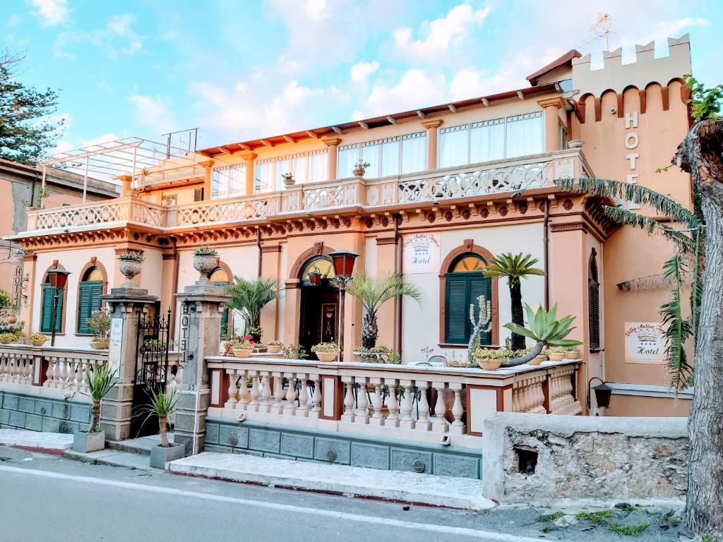 a large peach colored house with a balcony at Hotel Villa Antica Tropea in Tropea